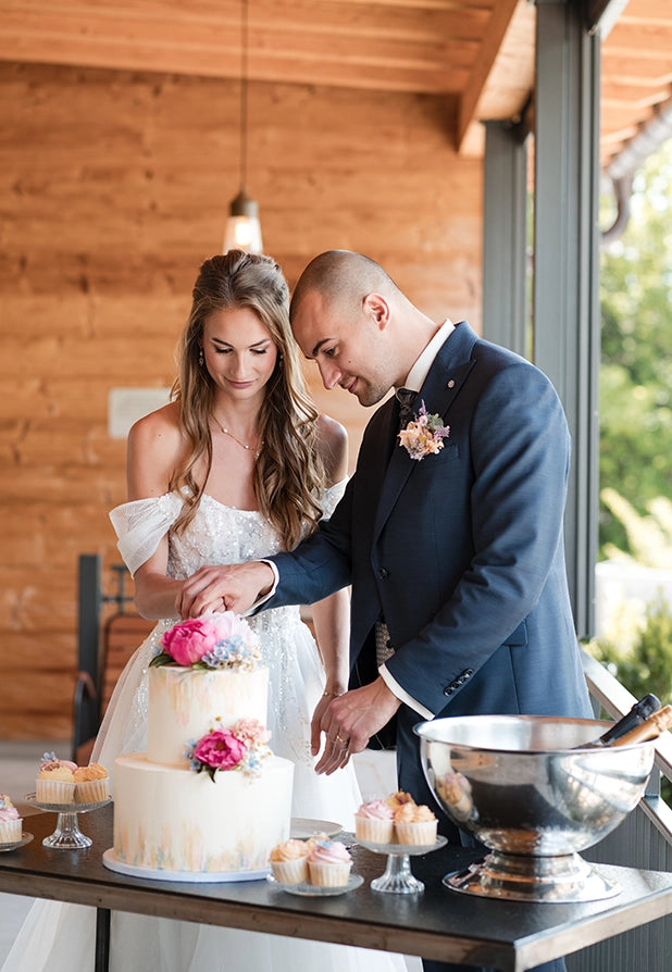 Suesse Freunde Styled Shoot Brautpaar schneidet Hochzeitstorte an